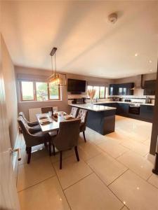 - une cuisine et une salle à manger avec une table et des chaises dans l'établissement Tide Cleddau impressive detached 4 bedroom home - Llanreath, à Llanstadwell