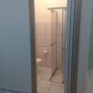 a bathroom with a toilet and a door open at Kitnets Plus in São Carlos +8 photos