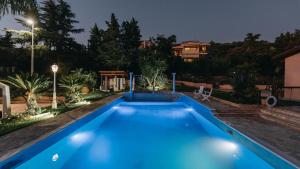 a swimming pool in a backyard at night at Crystal Villa Patras in Patra