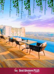 una fila de mesas y sillas en el techo de un edificio en Best Western PLUS Maya - Luxury Collection Hotel en Dhaka