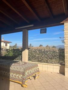 un patio con una mesa y una pared de piedra en Villa Multifamiliare a 300mt dal Mare, en Baia Domizia