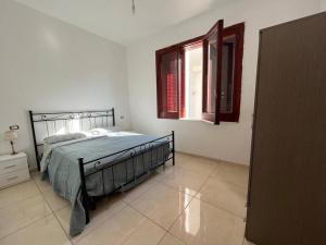 1 dormitorio con cama y ventana en Villa Multifamiliare a 300mt dal Mare, en Baia Domizia
