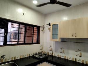 a kitchen with a ceiling fan and a sink at Just homes 2 bhk Service appt in Pune