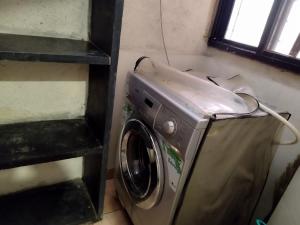 a washing machine in a room with a window at Just homes 2 bhk Service appt in Pune