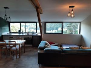 ein Wohnzimmer mit einem Sofa und einem Tisch in der Unterkunft Appartement chaleureux avec Jacuzzi in Banassac