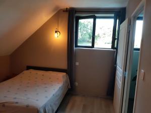 een kleine slaapkamer met een bed en een raam bij Appartement chaleureux avec Jacuzzi in Banassac
