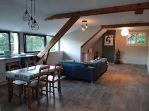 ein Wohnzimmer mit einem blauen Sofa und einem Tisch in der Unterkunft Appartement chaleureux avec Jacuzzi in Banassac