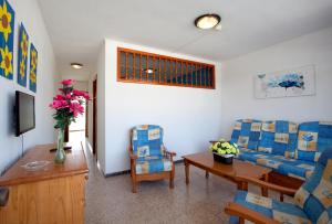 a living room with two chairs and a table and a tv at Apartamentos Europa in Maspalomas