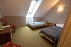 a attic bedroom with two beds and a skylight at Aiakeskuse hostel in Rakvere