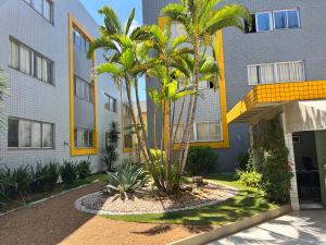 a building with palm trees in front of it at Multiparque Hplus Long Stay in Brasilia