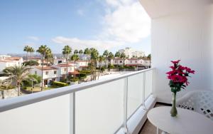 a balcony with a table and a vase of flowers at Apartamentos Europa in Maspalomas