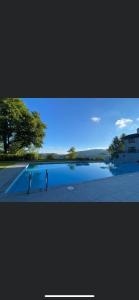 vistas a una piscina de agua junto a un edificio en gîte de montagne au pied du Champ du Feu (Alsace) en Belmont