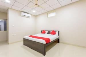 een slaapkamer met een bed met rode kussens erop bij JAGTARA RESIDENCY in Indore