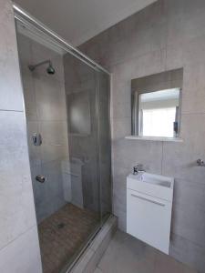 a bathroom with a shower and a toilet and a sink at 2-bedroom apartment in a security complex in Kimberley