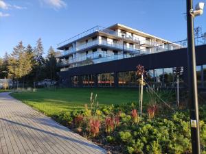 duży budynek z zielonym trawnikiem przed nim w obiekcie Marina View 15 & SPA w Dziwnowie