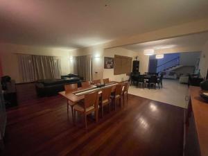 a living room and dining room with a table and chairs at Villa164 - Luxo, Piscina e Ginásio à beira-mar in Santa Maria