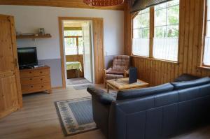 ein Wohnzimmer mit einem blauen Sofa und einem TV in der Unterkunft Gutzeit in Ädelfors