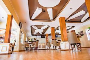 a salon with chairs and a table and a ceiling at Romeos Hotel in Kampala