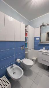 a blue and white bathroom with a toilet and a sink at Selenza Apartament in Wrocław