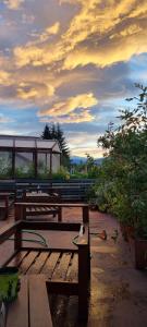 a group of park benches with a cloudy sky in the background at Posada del Buscador in El Bolsón