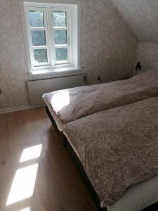1 dormitorio con cama y ventana en Skovhuset en Give
