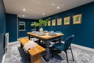 a dining room with blue walls and a table and chairs at St Johns, Wakefield - Self check in & free parking in Wakefield