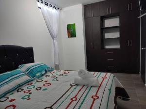 een slaapkamer met een bed met een knuffeldier erop bij Hermoso apartaestudio en el centro de Pereira in Pereira