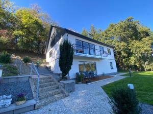 een wit huis met een veranda en een trap bij Traum Berg - Koppelberg 1 in Traben-Trarbach