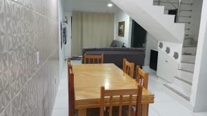 a dining room with a wooden table and chairs at Casa para temporada 50m da praia in Porto Seguro