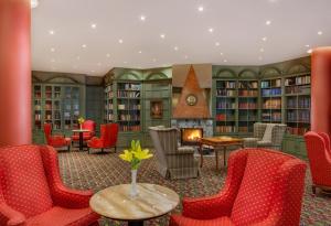 biblioteka z czerwonymi krzesłami i kominkiem w obiekcie Hotel Savoy Prague w Pradze