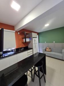 uma cozinha com um balcão e um sofá em Residencial Bombinhas em Bombinhas