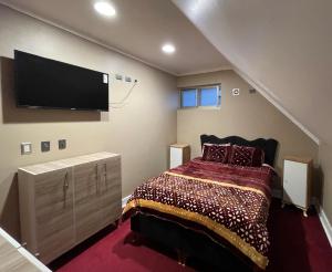 1 dormitorio con 1 cama y TV de pantalla plana en Casa Paraiso Hotel, en Santiago