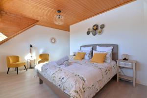 ein Schlafzimmer mit einem Bett und einer Holzdecke in der Unterkunft AU GRE DES SAISONS in Thannenkirch