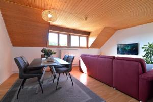 ein Wohnzimmer mit einem Sofa und einem Tisch in der Unterkunft AU GRE DES SAISONS in Thannenkirch
