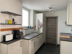 a kitchen with white cabinets and a sink and a door at Fewo Belinda, Tiengen Zentrum in Waldshut-Tiengen
