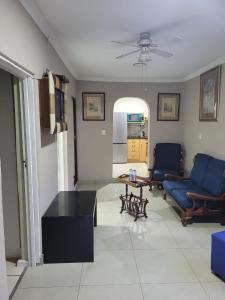 ein Wohnzimmer mit 2 blauen Stühlen und einem Tisch in der Unterkunft MO MAJOR in Kapstadt