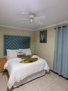 a bedroom with a large white bed with a fan at MO MAJOR in Cape Town
