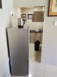 a refrigerator with a kettle on top of it in a kitchen at MO MAJOR in Cape Town