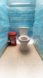 a bathroom with a toilet and a trash can at Hostal Playa Blanca in Playa Blanca