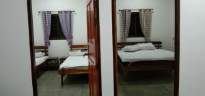 a bedroom with two bunk beds and a mirror at Yoga Homestay Seka in Seka
