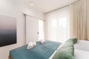 1 dormitorio con 1 cama con 2 toallas en Apartament PINE TREE SurfingBird Dźwirzyno en Dźwirzyno