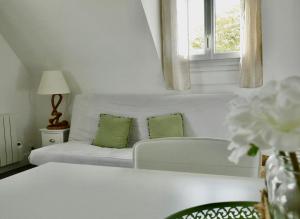 a white living room with a couch and a window at Appartement de l'Hippodrome avec deux chambres in Deauville