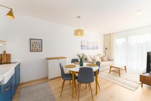 eine Küche und ein Wohnzimmer mit einem Tisch und Stühlen in der Unterkunft Apartament PINE TREE SurfingBird Dźwirzyno in Dźwirzyno