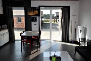 uma cozinha e sala de estar com mesa e cadeiras em Hoeve Megusta em Vlimmeren