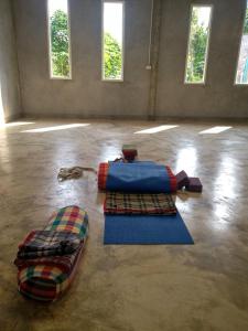 um quarto com dois tapetes no chão com janelas em Yoga Homestay Seka em Seka