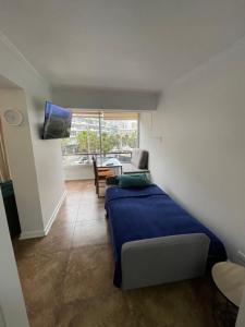 een slaapkamer met een bed, een tafel en een raam bij Centromar 302 a pasos de todo in Viña del Mar