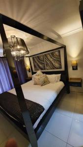 1 dormitorio con 1 cama con marco de madera en Upmarket 3 Bedroom Apartment, en Johannesburgo