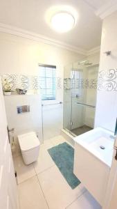 a bathroom with a toilet and a sink and a shower at Upmarket 3 Bedroom Apartment in Johannesburg