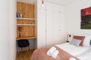 a bedroom with a bed and a chair in it at Apartament WILLOW TREE SurfingBird Dźwirzyno in Dźwirzyno