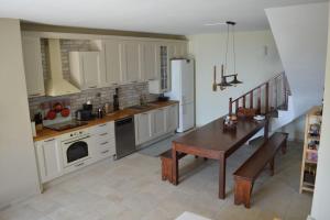 a kitchen with white cabinets and a wooden table and a table and a tableablish at Villa Consta in Tsagarada